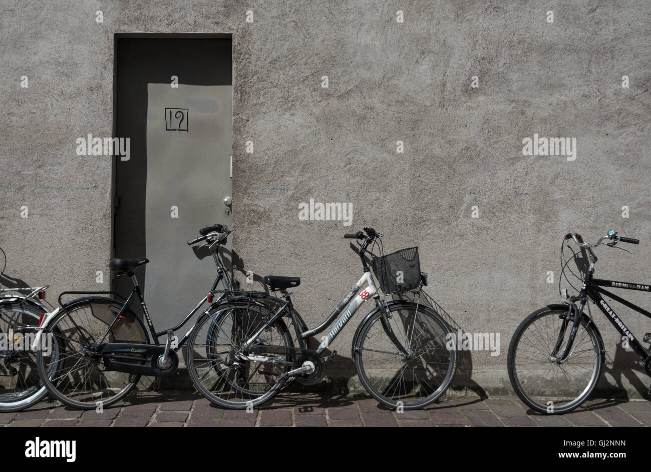 Bruges noleggio bici. Aperto ogni giorno per il noleggio della bicicletta intorno alla città. Biciclette appoggiata contro una parete per le strade di Bruges. Foto Stock