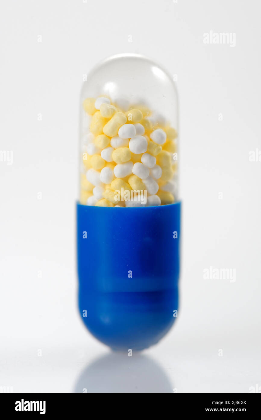 Pillola trasparente capsula con granuli colorati Foto Stock