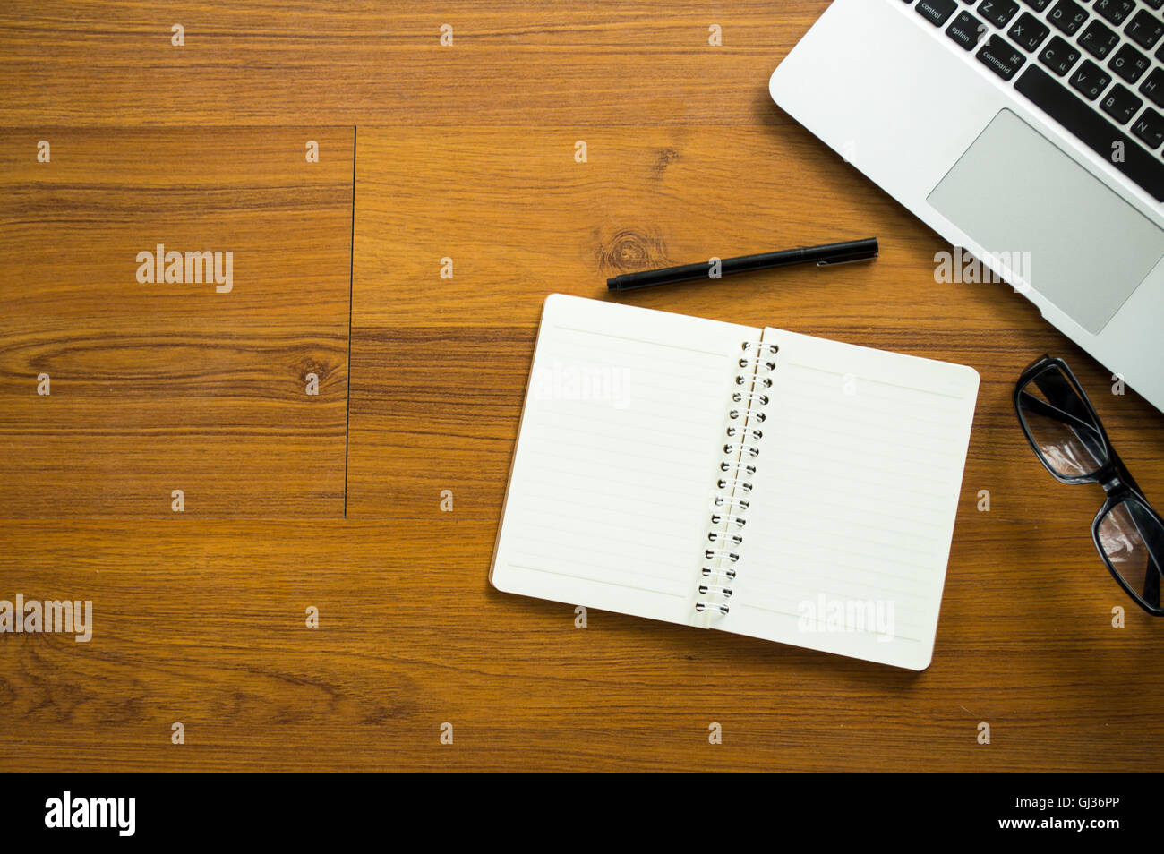 Carica tabella con notepad, laptop e la tazza di caffè.Vista da sopra con copia spazio. Foto Stock