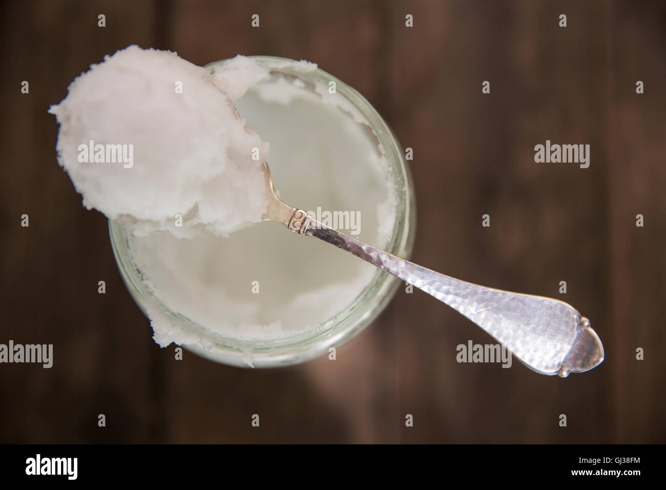 Vista aerea del cucchiaio di freddo Olio di noce di cocco sul jar Foto Stock