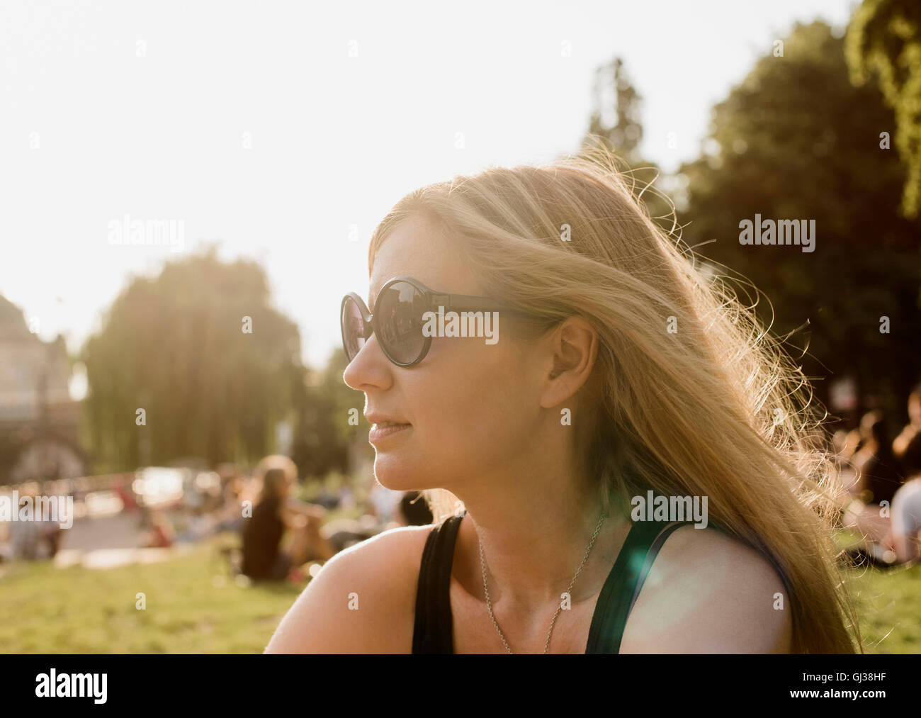 Giovane donna nel parco, guardando lontano Foto Stock