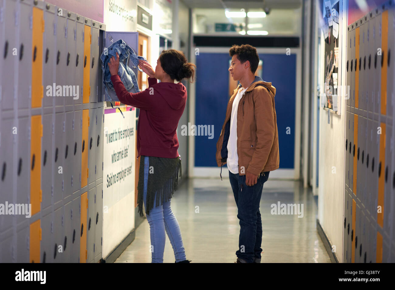 Giovane studentessa rimozione camicia da college locker Foto Stock