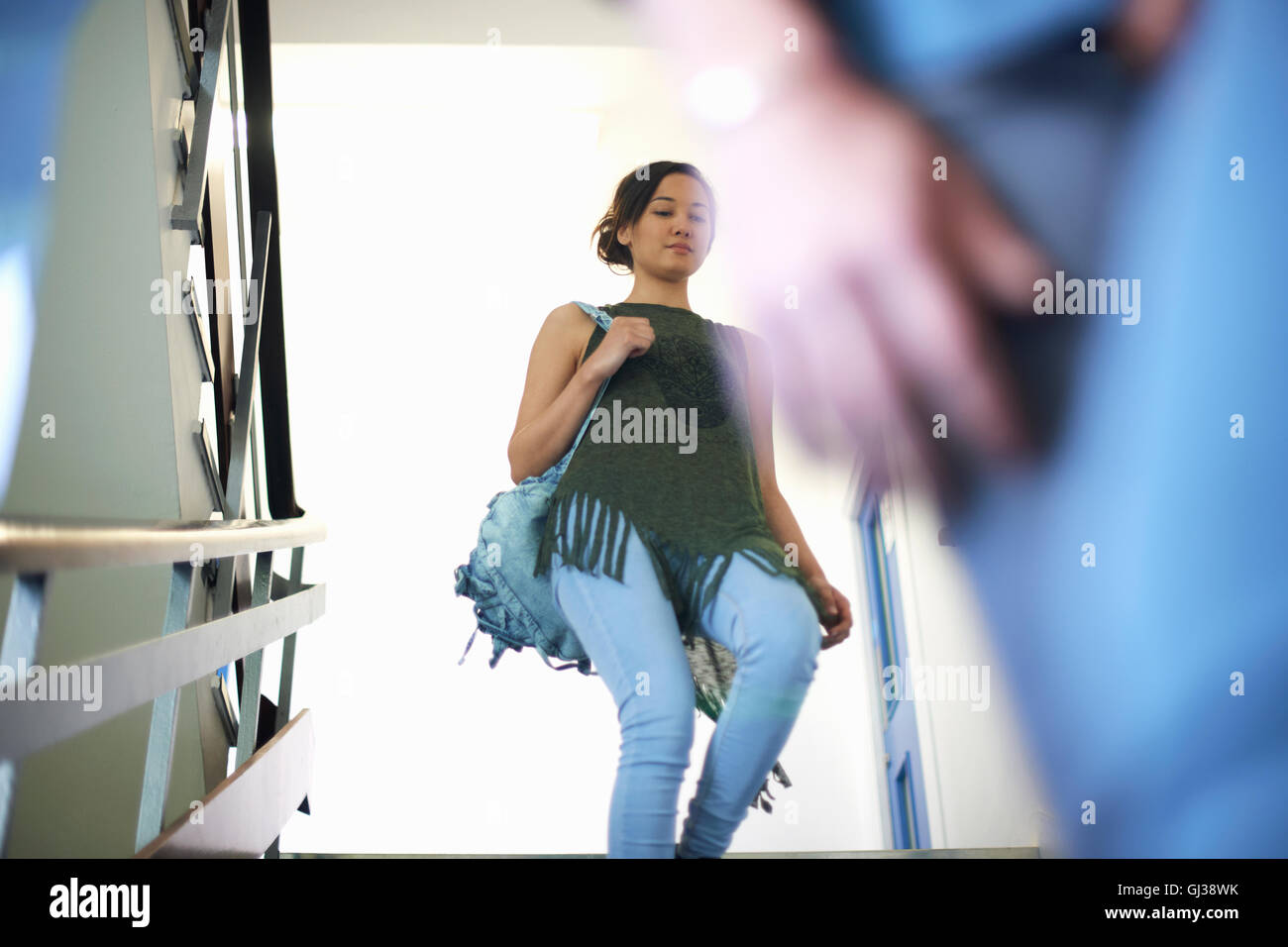 Femmina giovane studente di college si sta spostando verso il basso le scale Foto Stock
