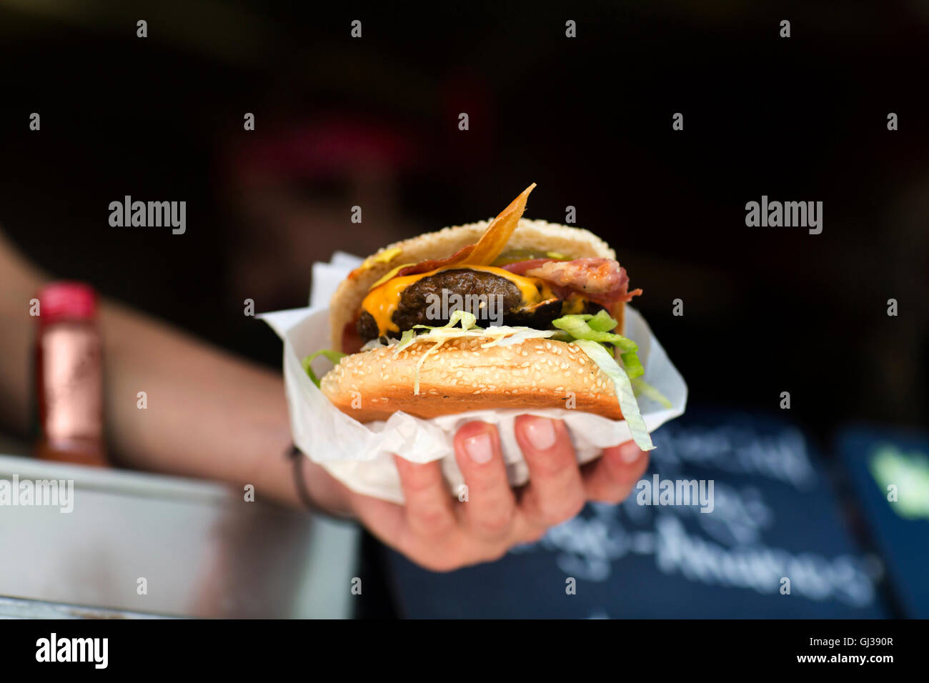 Man mano che serve hamburger da fast food van Foto Stock