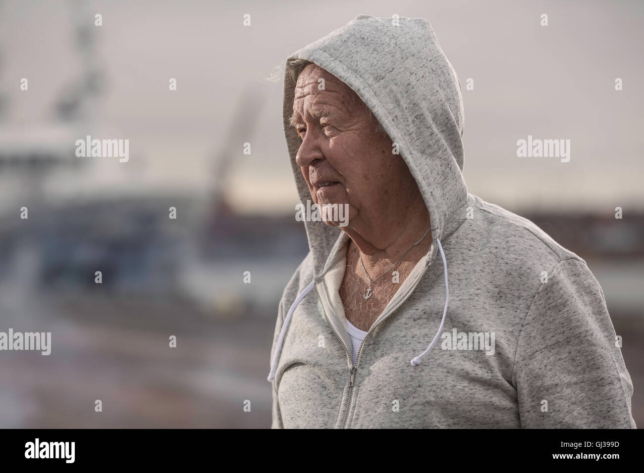 Uomo che indossa top con cappuccio che guarda lontano Foto Stock