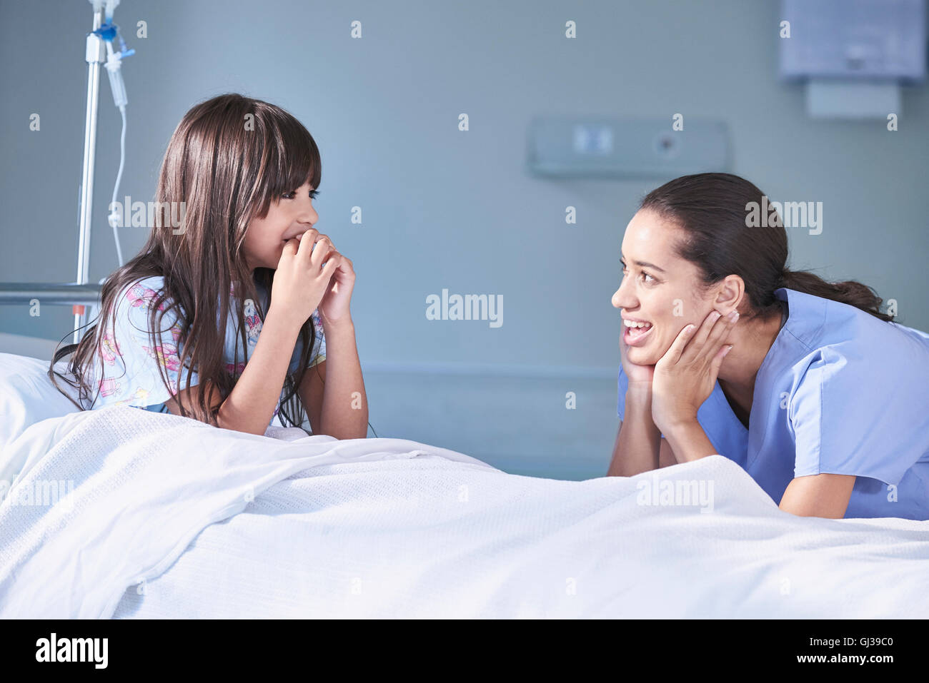 Ragazza paziente parla a femmina infermiera in ospedale per bambini ward Foto Stock