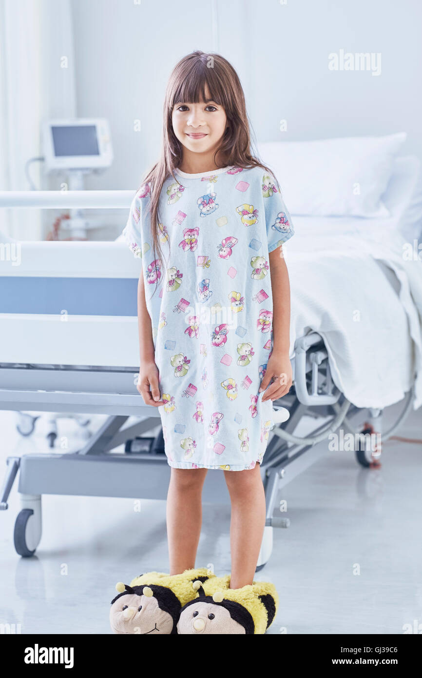 Ritratto di ragazza paziente che indossa bumblebee pantofole in ospedale per bambini ward Foto Stock