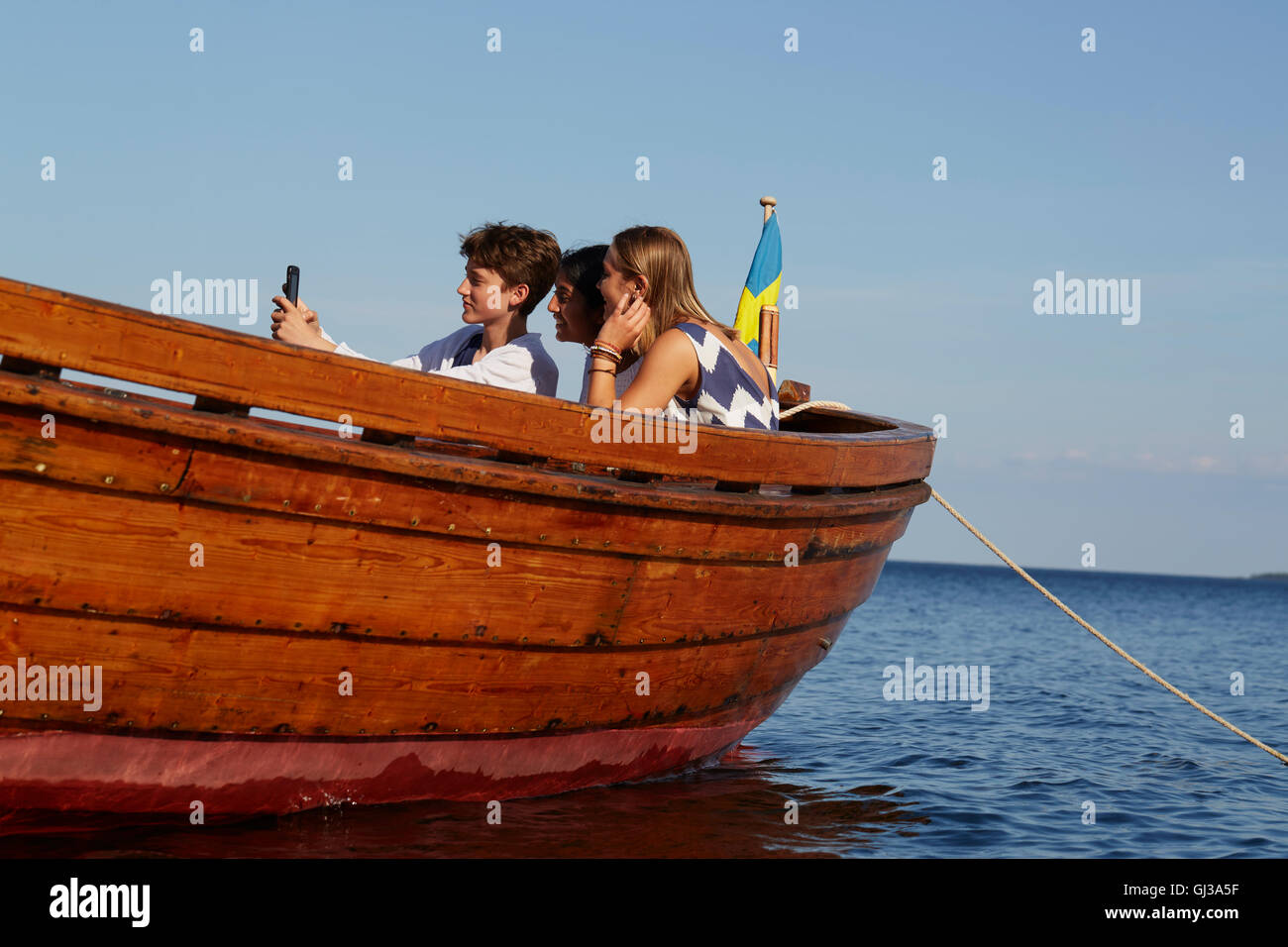 Amici sulla barca tenendo selfie Foto Stock