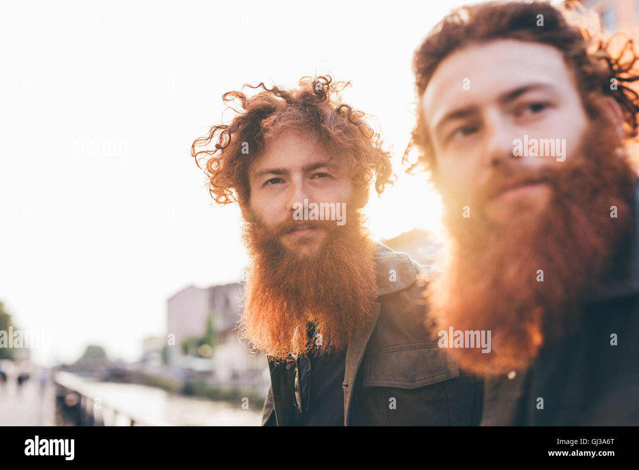 Giovane maschio hipster gemelli con i capelli rossi e le barbe sul canal waterfront Foto Stock