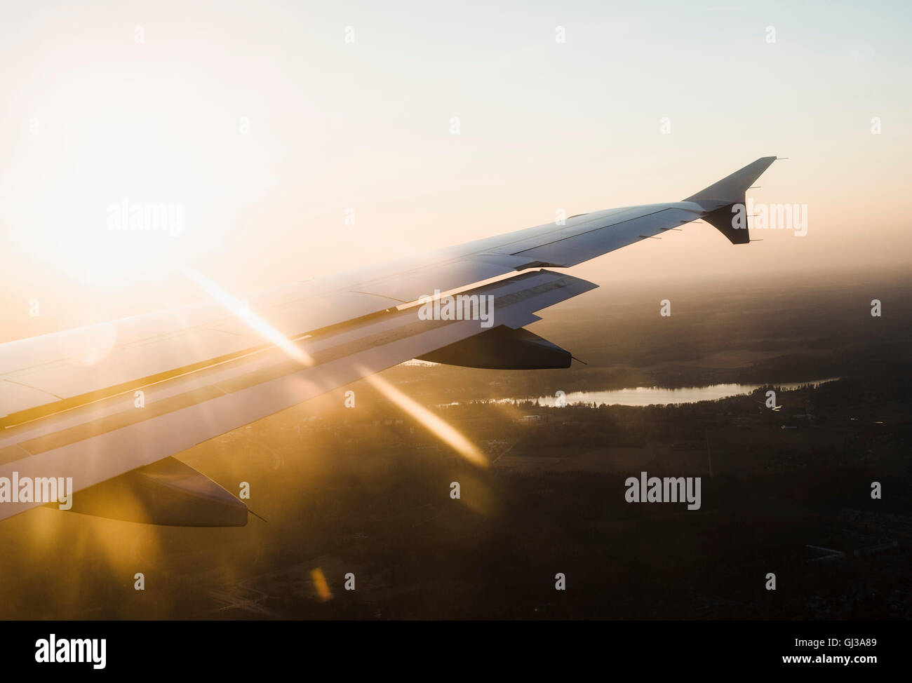 Vista in elevazione dell'ala di aeroplano su stagliano paesaggio al tramonto, Finlandia Foto Stock