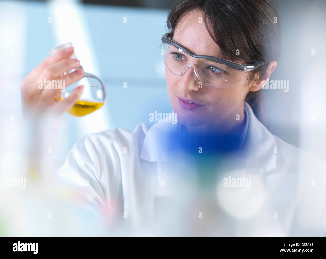Visualizzazione dello scienziato formula chimica nel becher durante l'esperimento in laboratorio Foto Stock