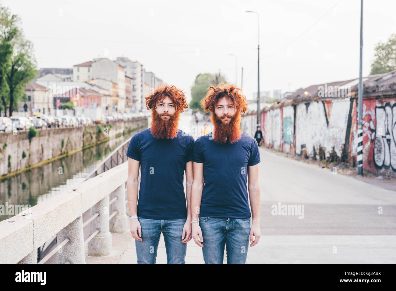 Ritratto di giovane maschio hipster gemelli con i capelli rossi e le barbe in piedi sul ponte Foto Stock