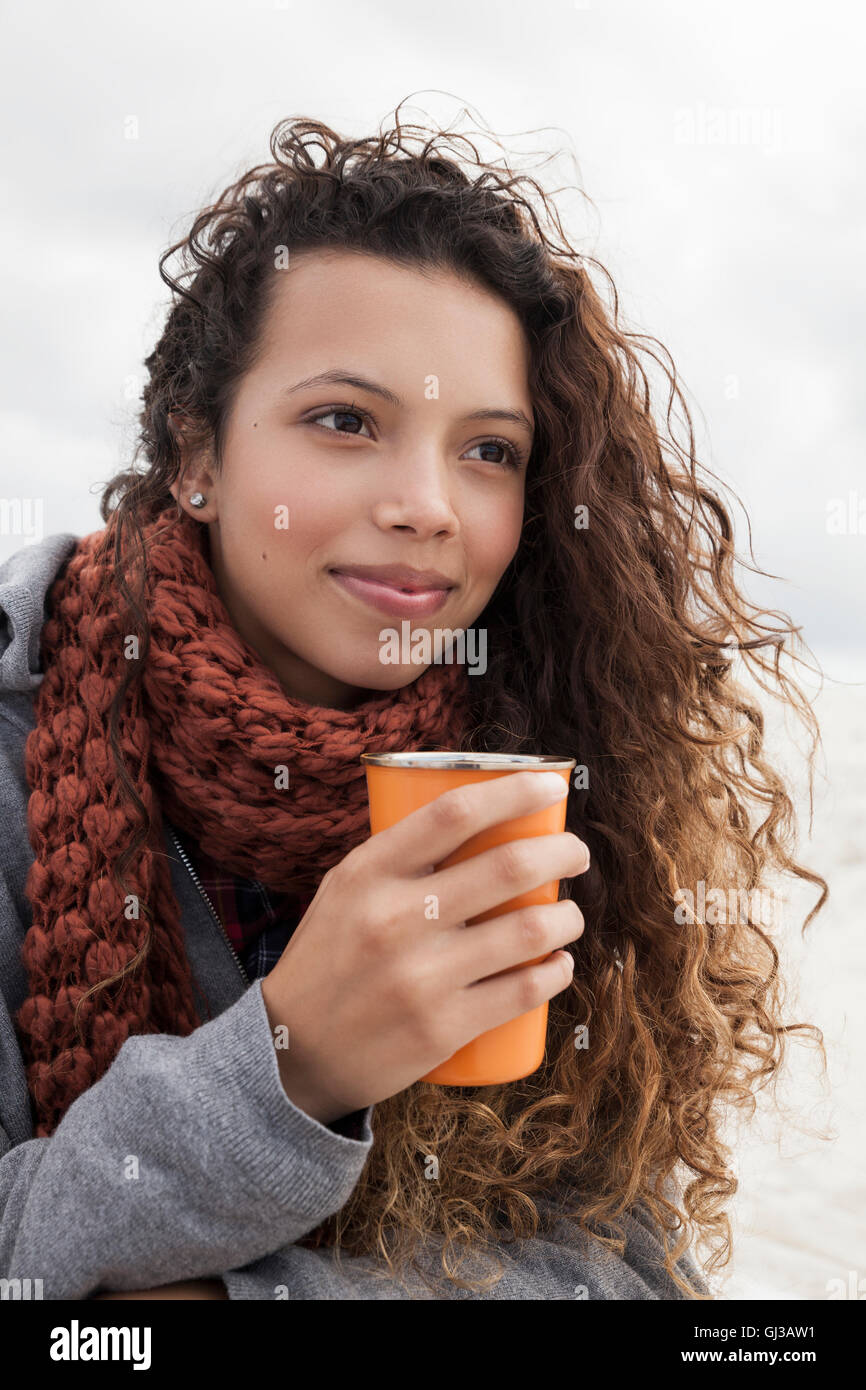 Giovane donna azienda tazza di caffè sul freddo giorno Foto Stock