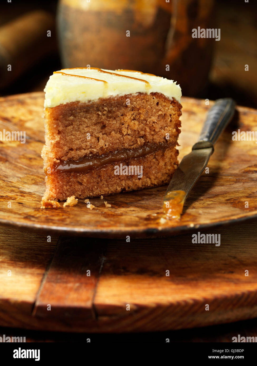 Banoffee cake, piatto in legno, coltello vintage Foto Stock