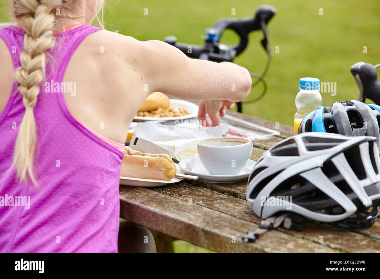 Ciclista con la colazione a tavola di picnic Foto Stock