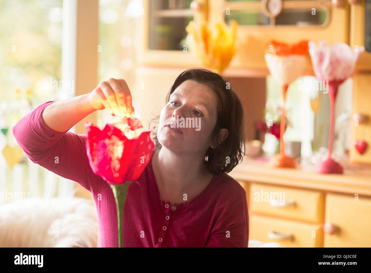 Donna che fa la lampada di carta a casa Foto Stock