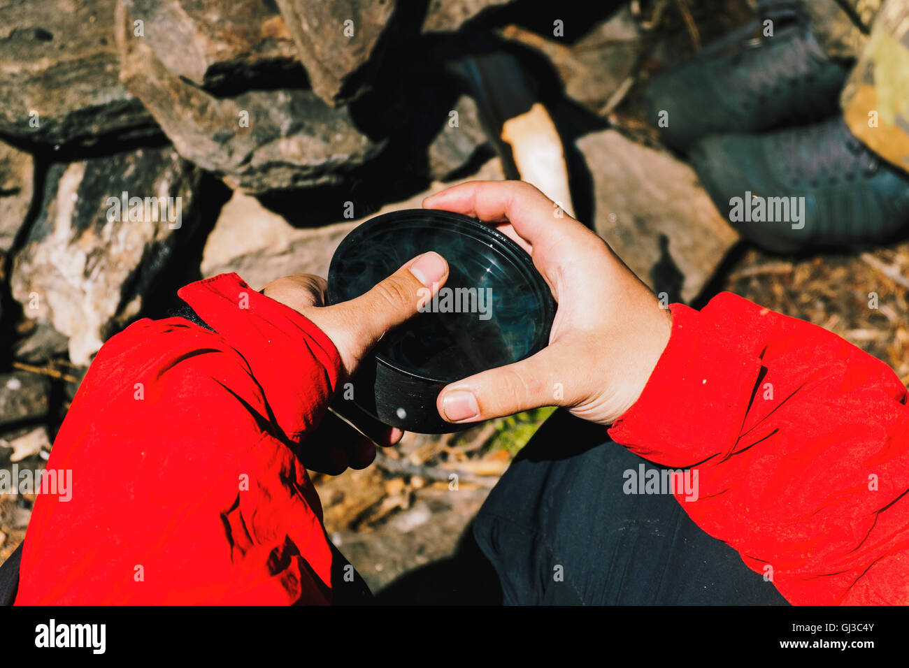 Le mani dei maschi di escursionista holding tazza di tè, Russia Foto Stock