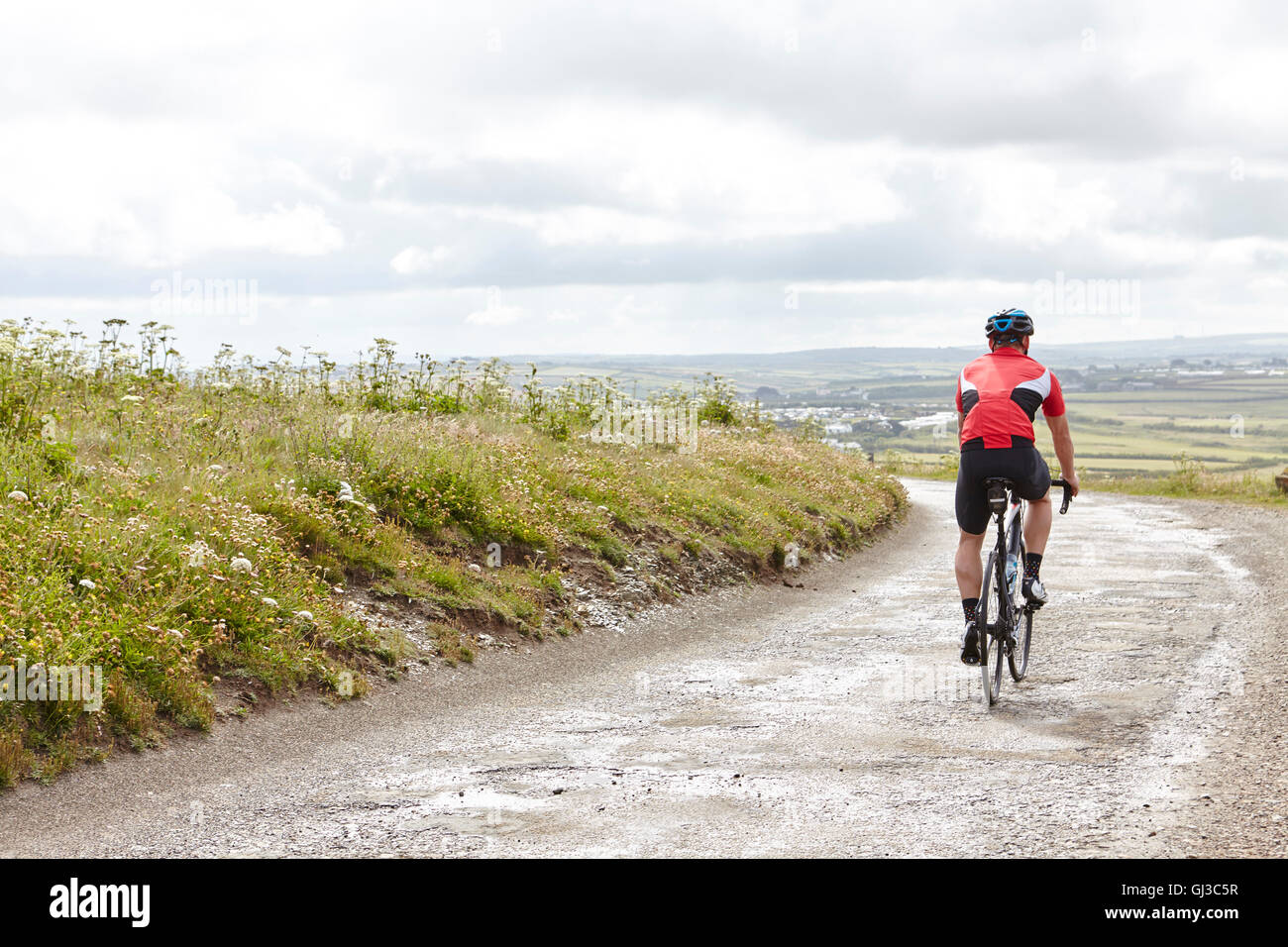 Ciclista equitazione sulla strada di campagna Foto Stock