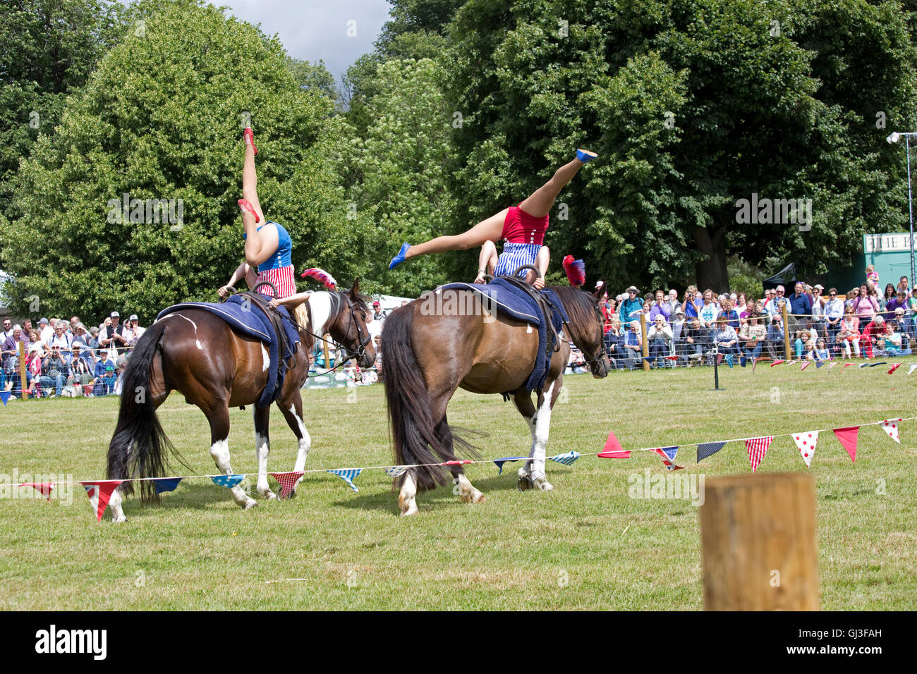 La folla guarda due ragazze facendo acrobazie sul retro cavallo al galoppo Countryfile Live Blenheim REGNO UNITO Foto Stock