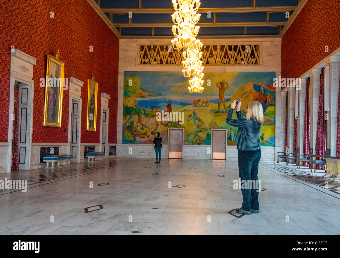 Persona di scattare le foto della sala banchetti con murale da saranno Midelfart, Municipio di Oslo, Oslo, Norvegia, Scandanavia Foto Stock