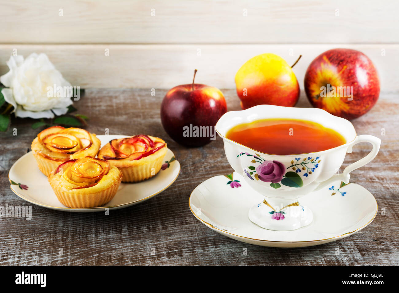 Tazza di tè e apple a forma di rosa muffin. In casa torta di mele per il tè in tempo. Colazione tè con dolci di pasticceria di apple. Foto Stock