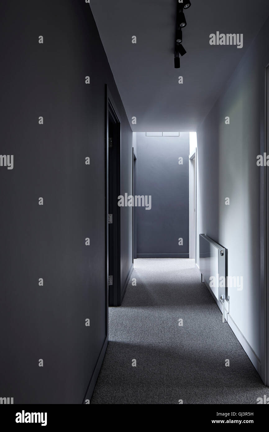 Tono scuro corridoio con illuminazione soffusa. Casa abbinato, Beaconsfield, Regno Unito. Architetto: GLAS Architetti, 2016. Foto Stock