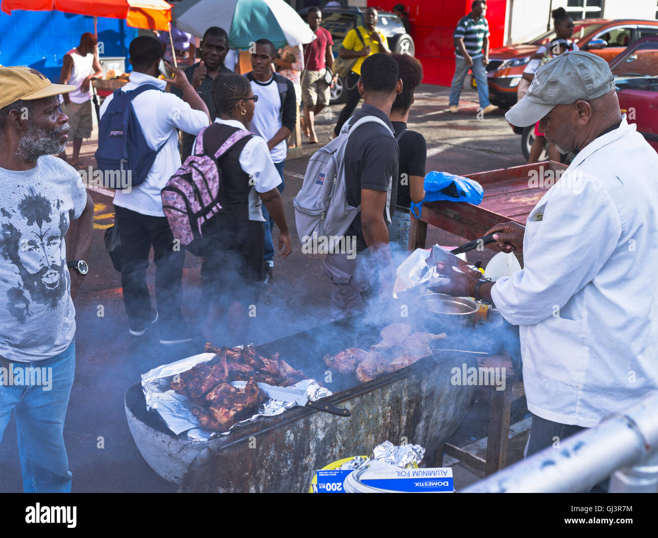 dh St George GRENADA CARIBBEAN Food Street mercato barbecue uomo cucina pollo gente locale Foto Stock