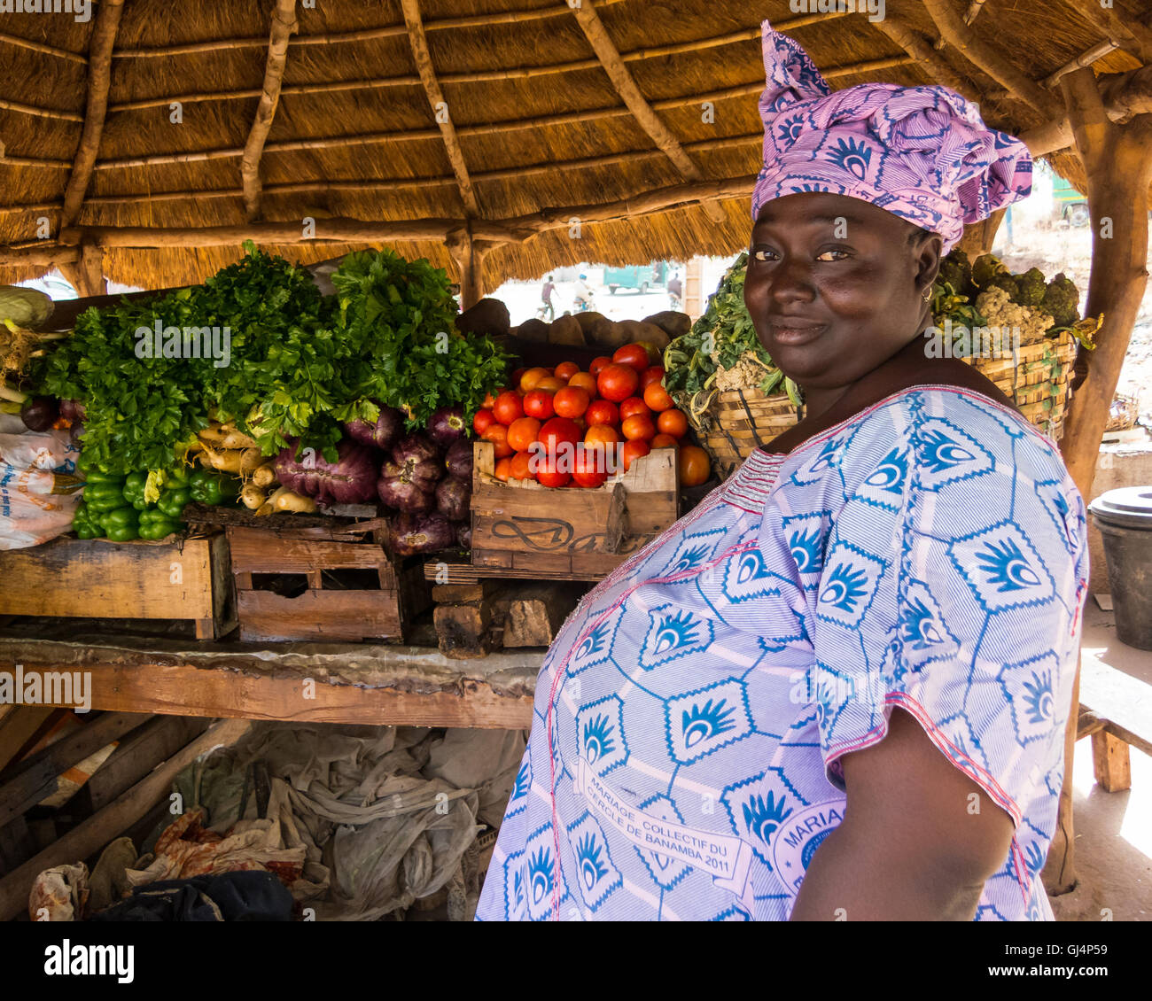 BAMAKO, MALI - CIRCA FEBBRAIO 2012: Donna maliana che vende verdure sul lato della strada. Foto Stock