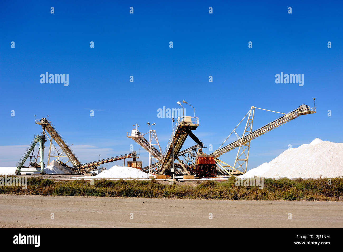 Funzionamento del sito sale marino di Aigues-Mortes salina con grandi macchine e camion che lavorano per la memorizzazione di sale Foto Stock