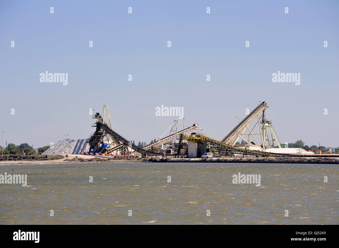 Funzionamento del sito sale marino di Aigues-Mortes salina con grandi macchine e camion che lavorano per la memorizzazione di sale Foto Stock