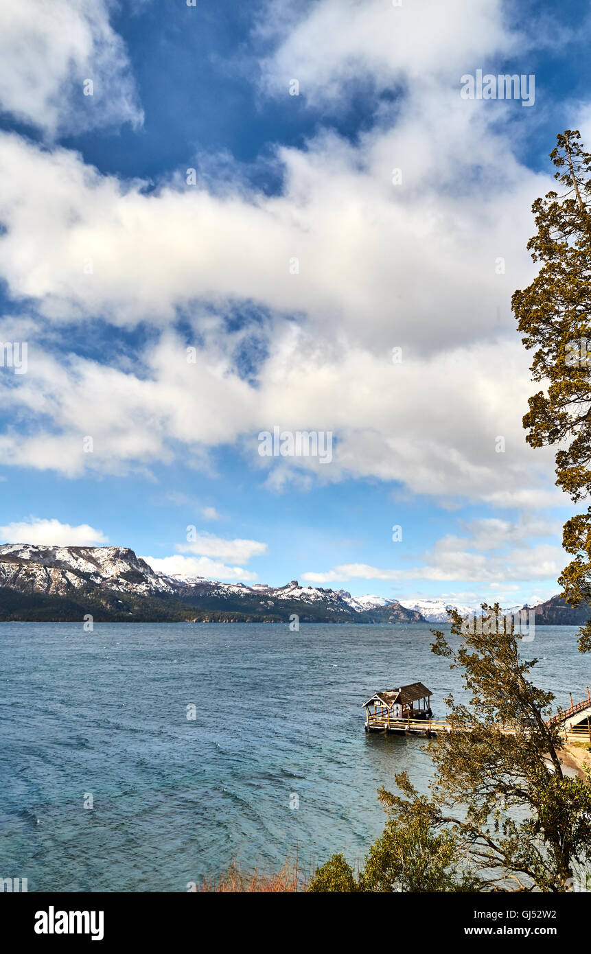 Una vista del dock e il lago di Villa Traful con alcune montagne e un cielo nuvoloso Neuquen, Argentina. Foto Stock