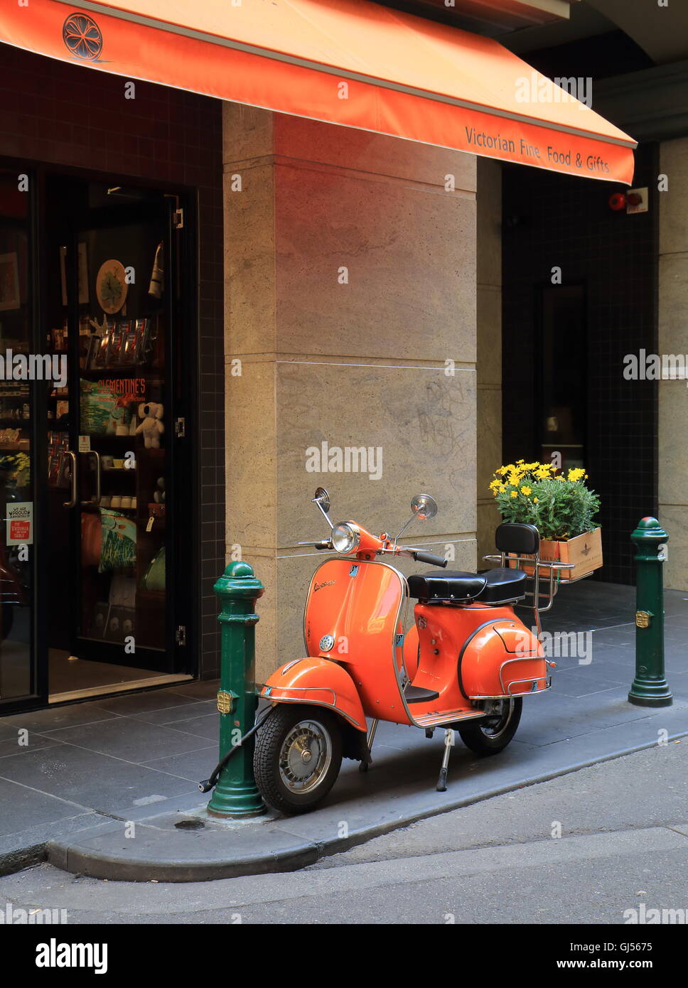 Orange Vespa parcheggiata nel centro cittadino di Melbourne Foto Stock