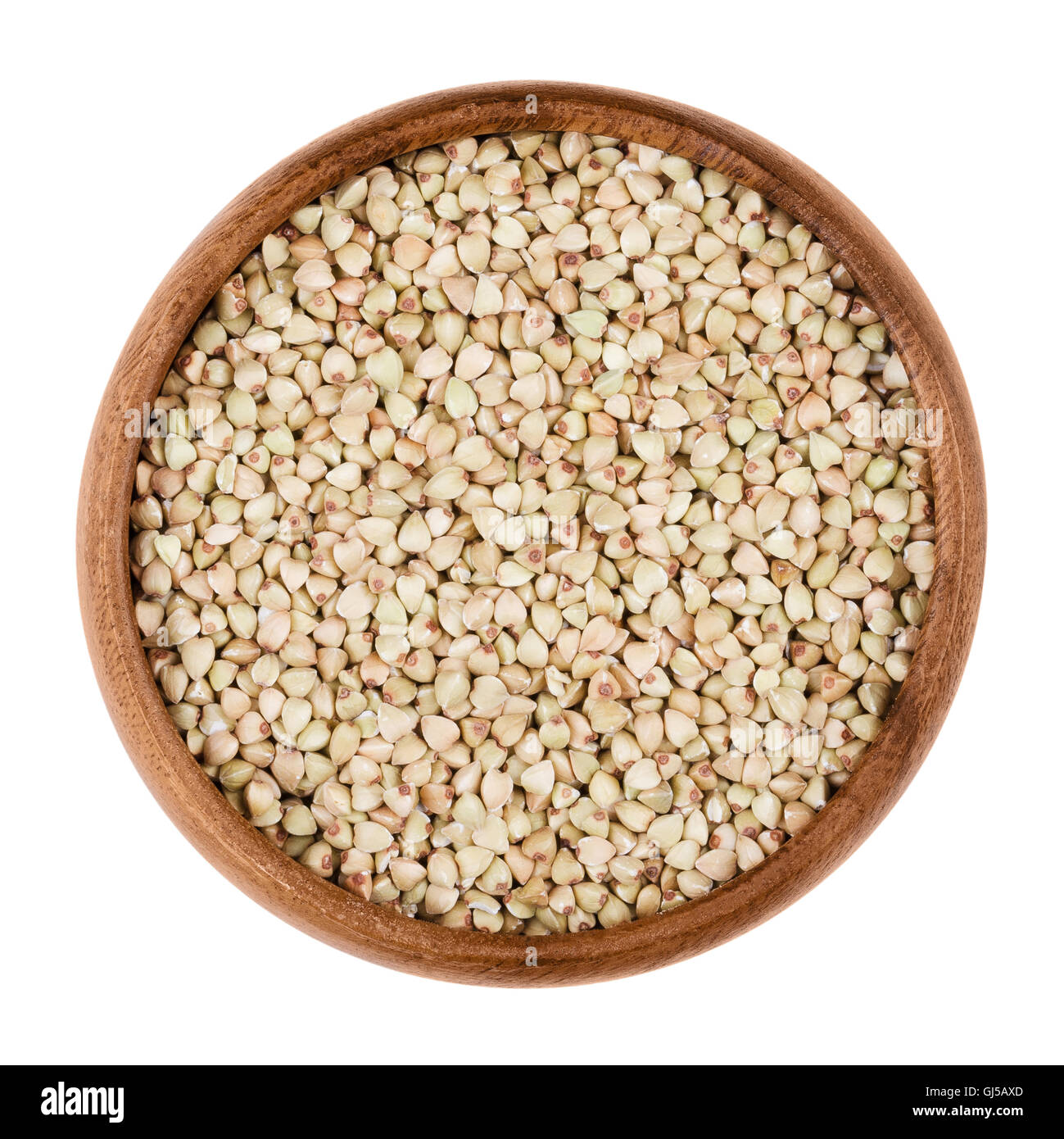 Il grano saraceno in una ciotola di legno su sfondo bianco. Piccoli semi di grano di Fagopyrum esculentum. Commestibile, materie e cibo biologico. Foto Stock