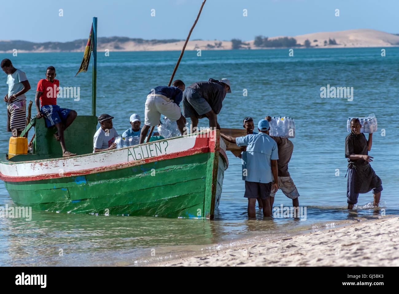 La gente del posto lo scarico di una dhow con disposizioni sulla spiaggia di Isola di Benguerra Mozambico Foto Stock