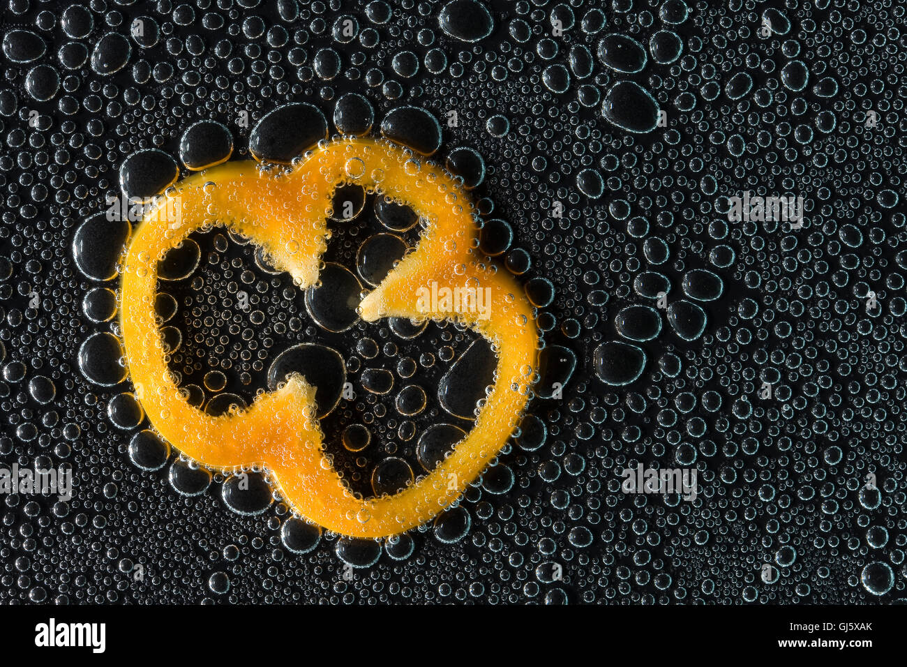 Fetta di peperone dolce in acqua minerale, una serie di foto. Close-up di acqua gassata su sfondo nero Foto Stock