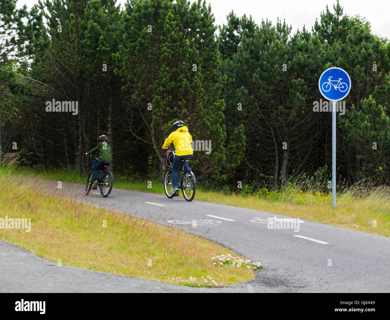 Madre e figlio ciclismo su pista ciclabile in zona ricreativa Öskjuhlíð Hill Reykjavik Islanda Europa Foto Stock