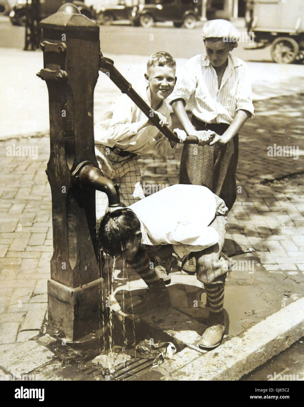 Ragazzi ottenere acqua in una giornata calda da una vecchia pompa disposta su Pennsylvania Avenue non lontano dalla Casa Bianca. Foto Stock