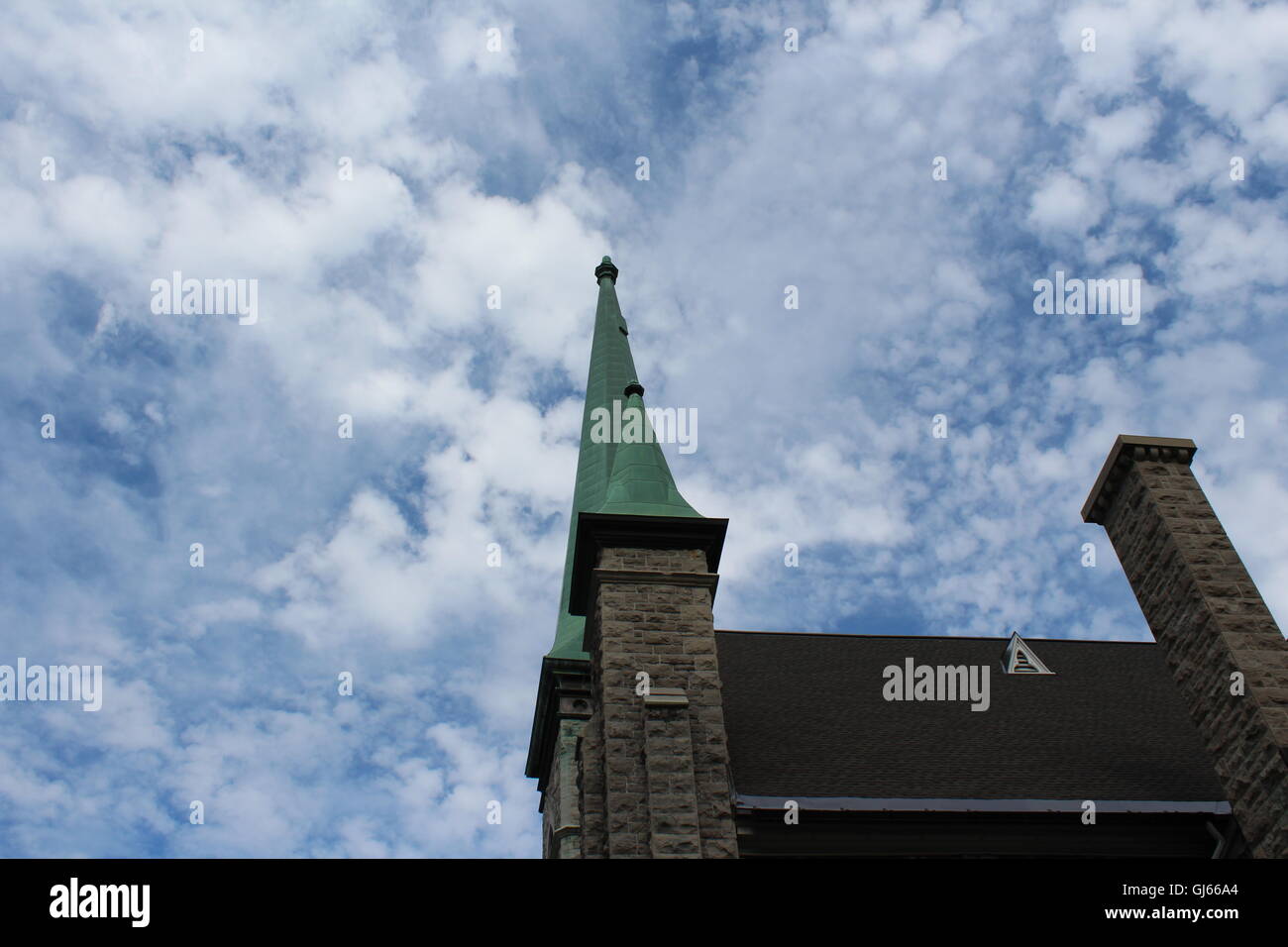 Edificio alto con camino, girato dal lato, con il costrutto di roccia, disegni rivolto verso il cielo blu con nuvole Foto Stock
