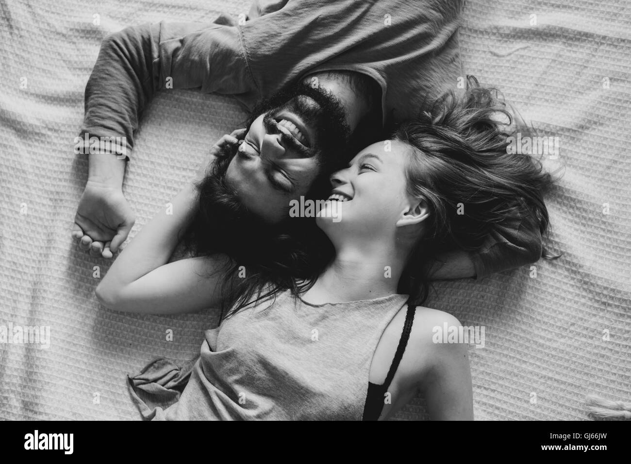 Giovane che stabilisce nel loro letto, momento divertente, divertentissimo, scherzando, sorridente Foto Stock