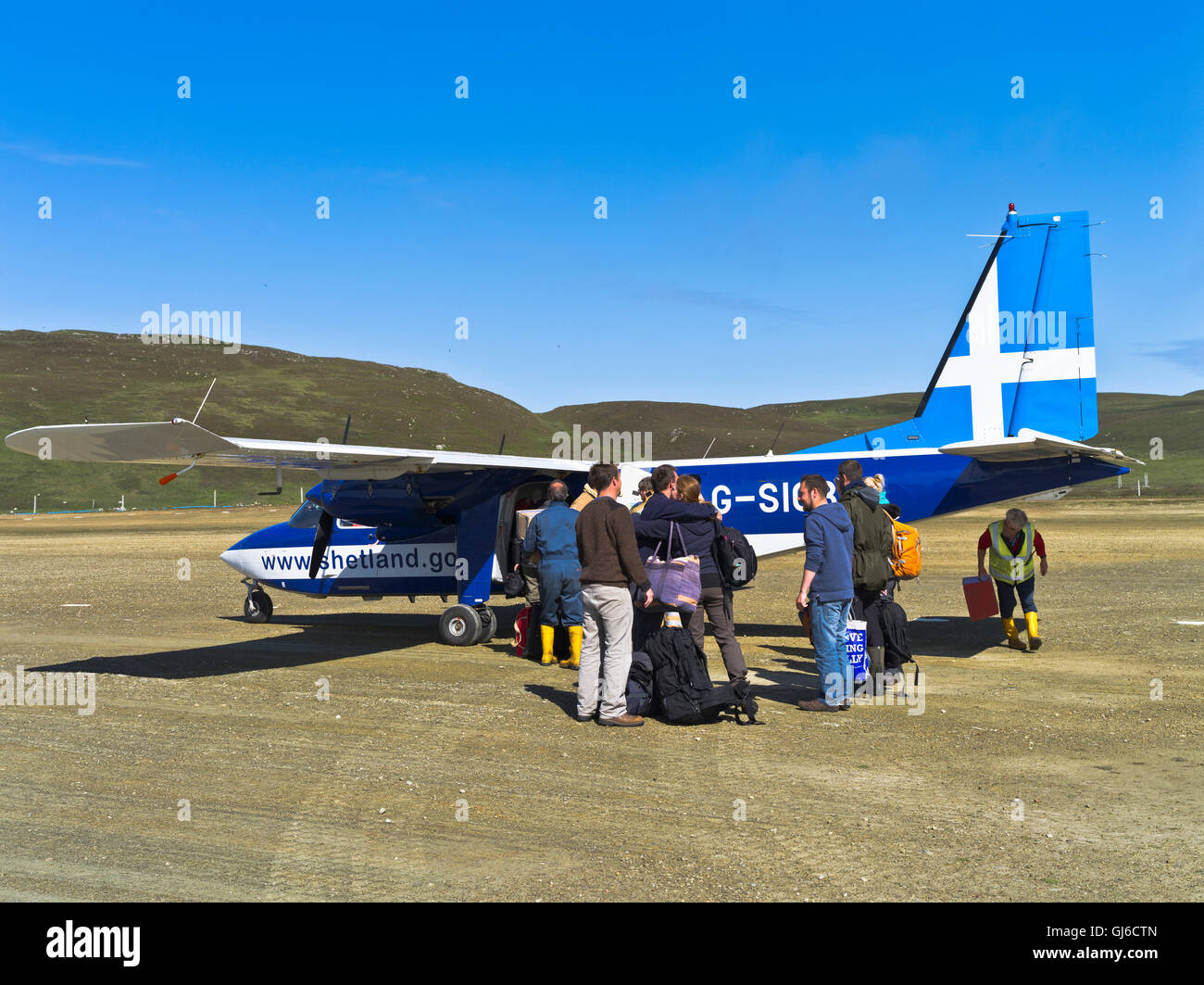dh piccolo turboprop aereo FIERA ISLES AEROPORTO FIERA ISLE SCOZIA Passeggeri in partenza, persone che si imbarcheranno sulla pista di atterraggio dell'aereo dell'islander parcheggiata Foto Stock
