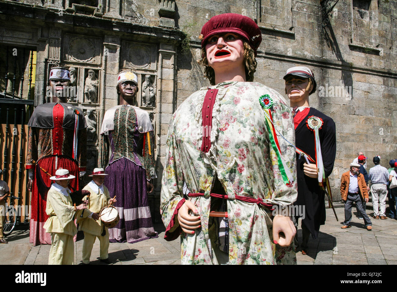 Enorme cartapesta bambole con un essere umano all'interno di ciascuna una sfilata per Santiago.Nota la cornamusa, un popolare galiziano musical instr Foto Stock