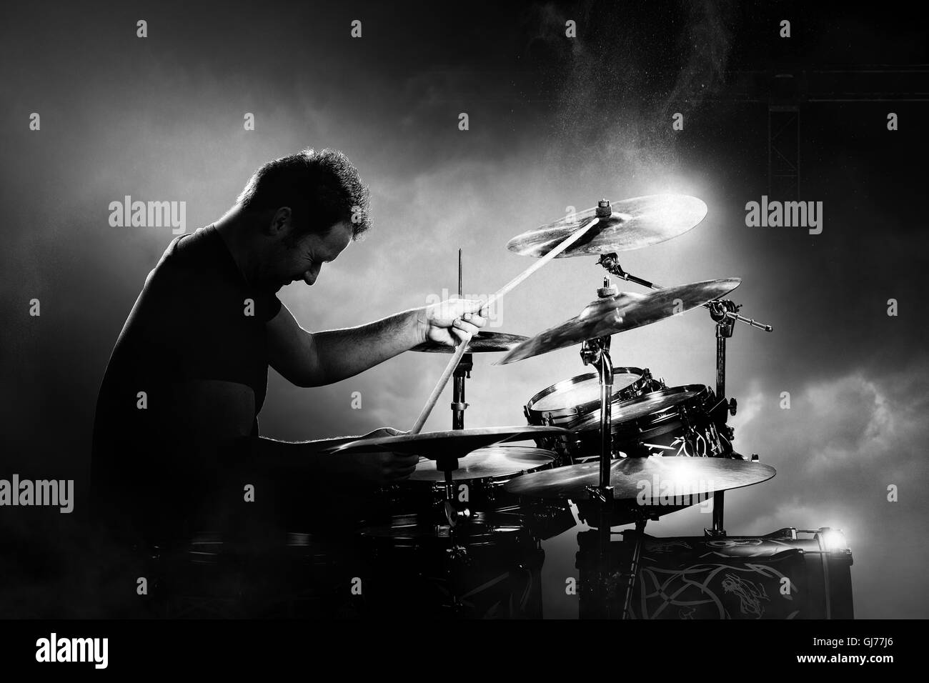 Il batterista a suonare la batteria con fumo e polvere in background Foto Stock