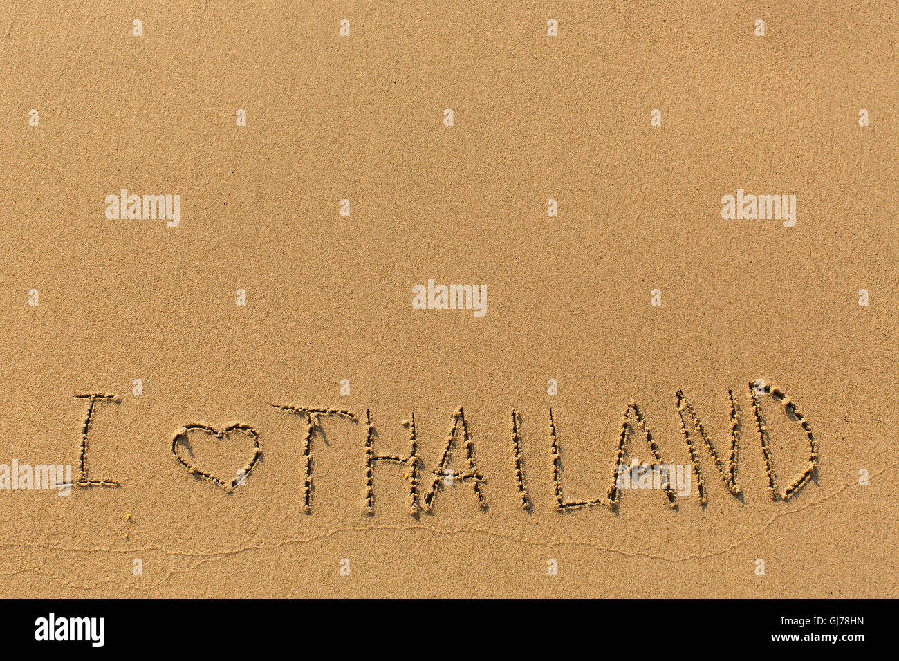 Io amo la Thailandia - scritti manualmente nella linea di navigare in sabbia di mare. Foto Stock
