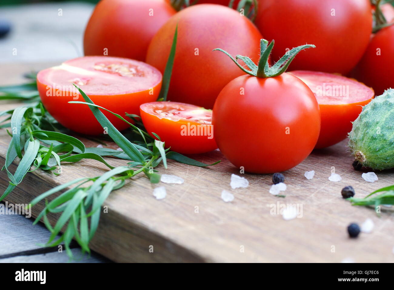 I pomodori e le erbe su un tagliere Foto Stock