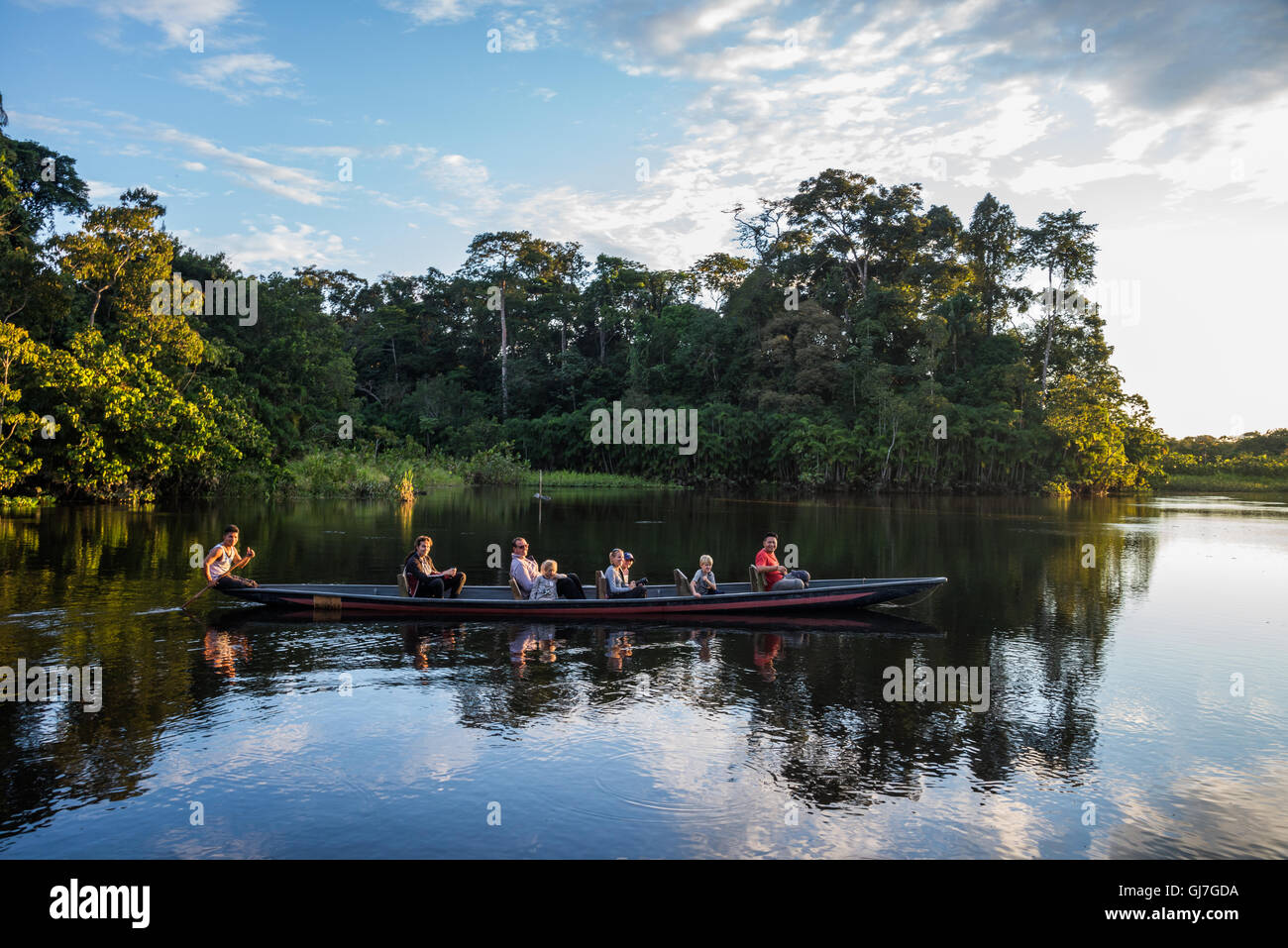Una canoa con turisti pagaiando su Amazon al tramonto. Yasuni National Park, Ecuador, Sud America. Foto Stock