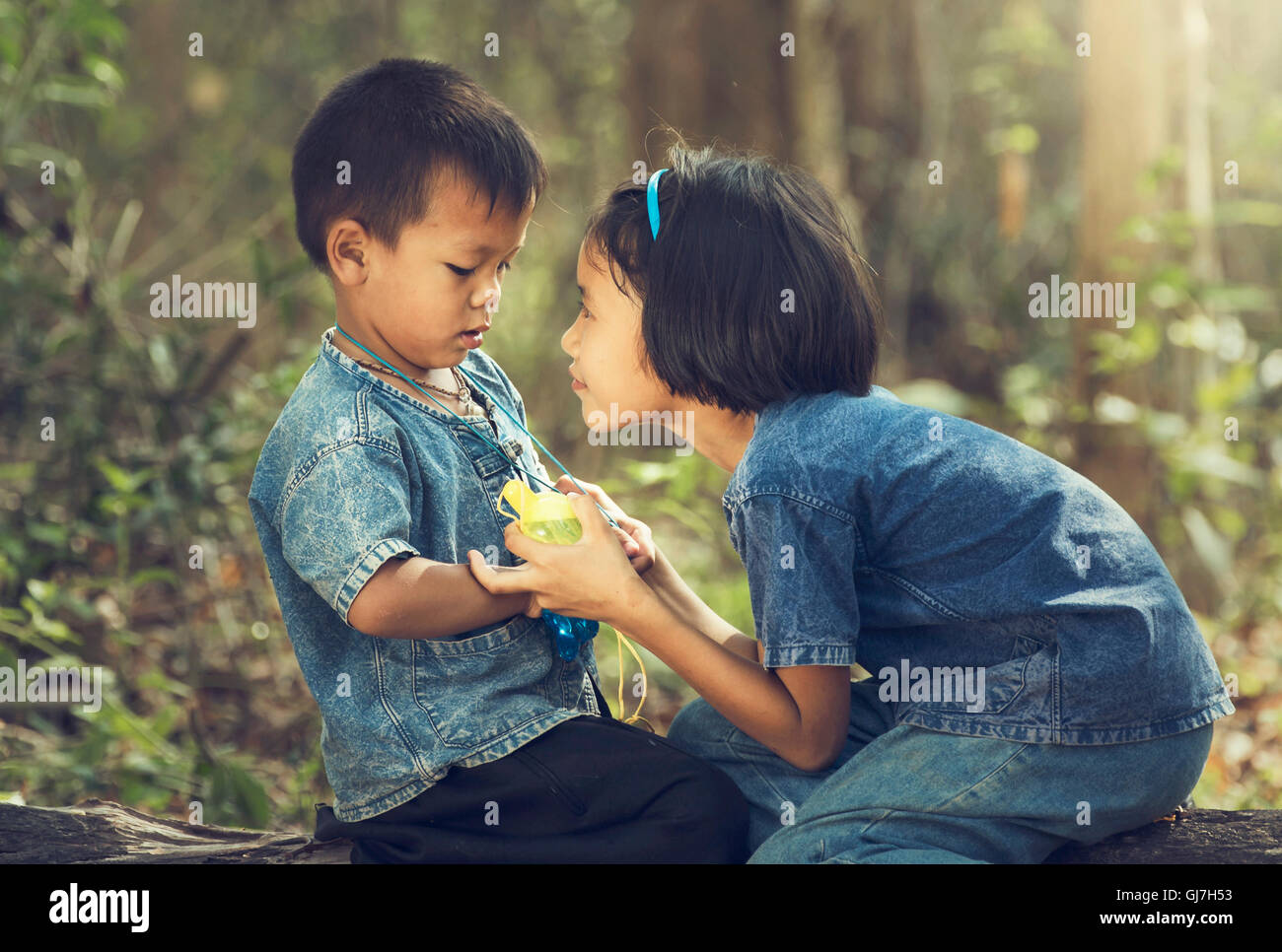 Asian, sorella e fratello sarà negoziato nel riprodurre le bolle da una bottiglia. Foto Stock