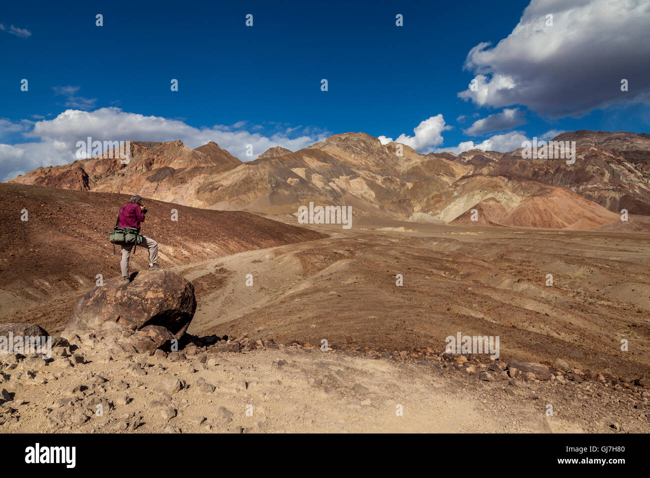 Uomo di fotografare le rocce sedimentarie vulcaniche sulle colline vicino a artista della tavolozza, Parco Nazionale della Valle della Morte, CALIFORNIA, STATI UNITI D'AMERICA Foto Stock