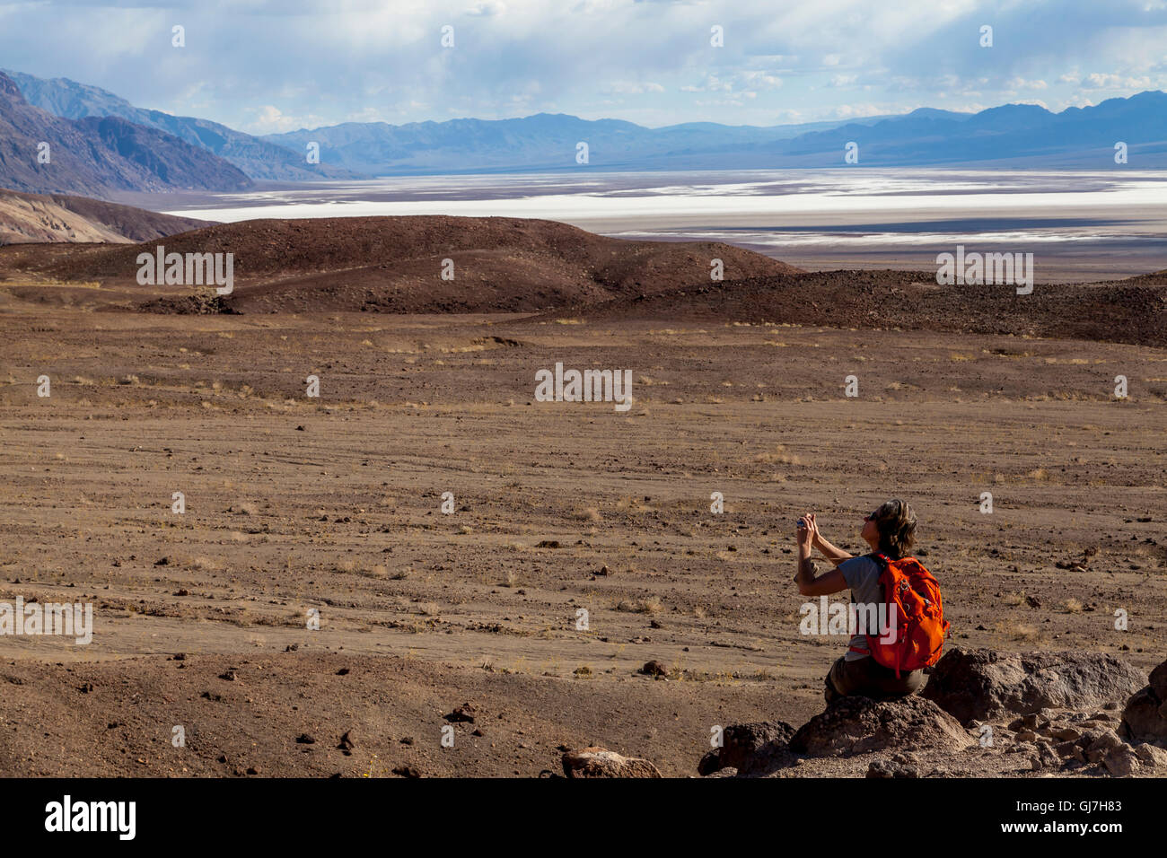Turista femminile di scattare foto da vulcaniche e rocce sedimentarie sulle colline vicino a artista della tavolozza in Parco nazionale della Valle della Morte, Califo Foto Stock