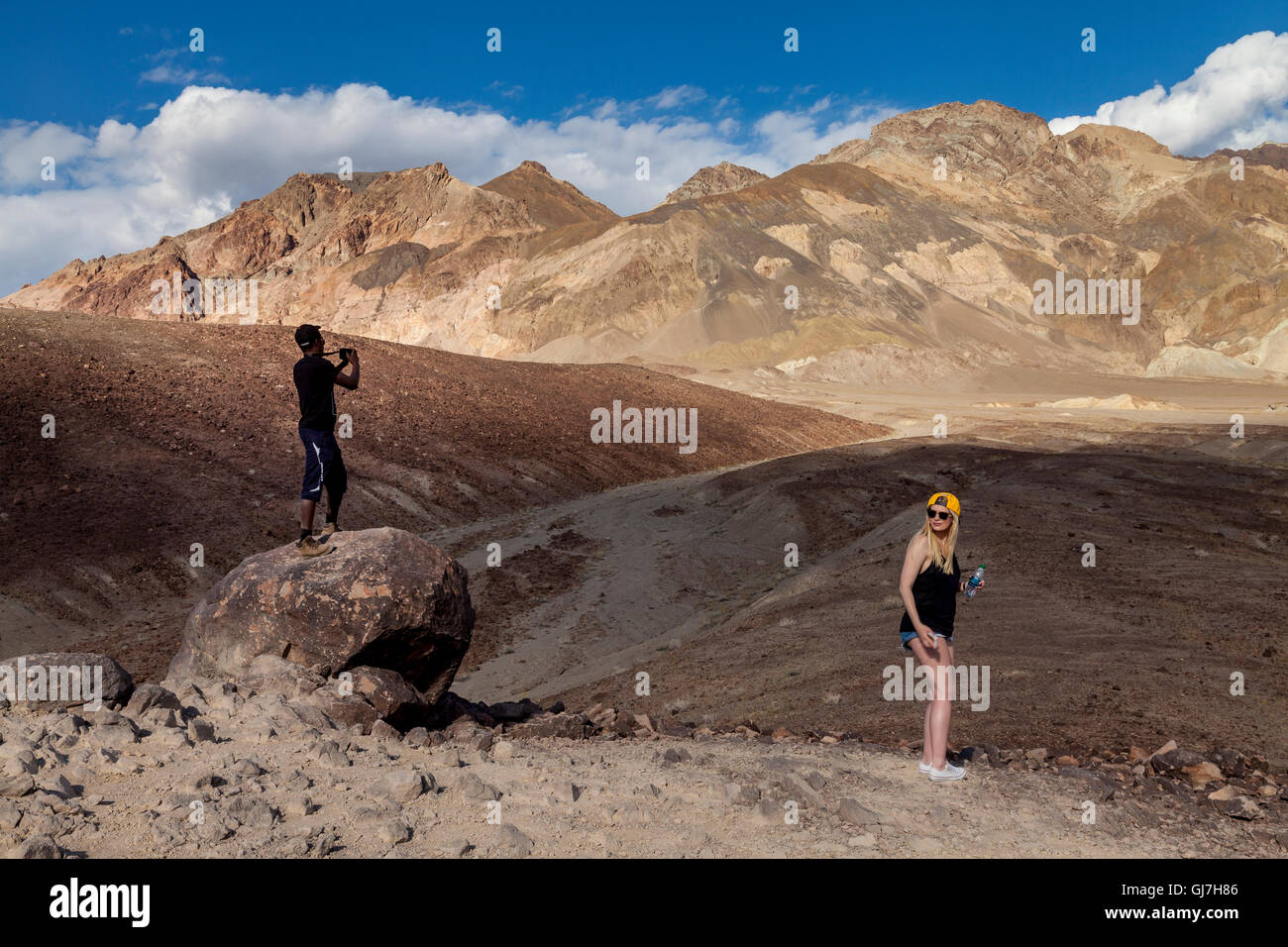 Maschio nero turistica prendendo immagini a vulcaniche e rocce sedimentarie sulle colline vicino a artista della tavolozza, donna caucasica guardando, Deat Foto Stock