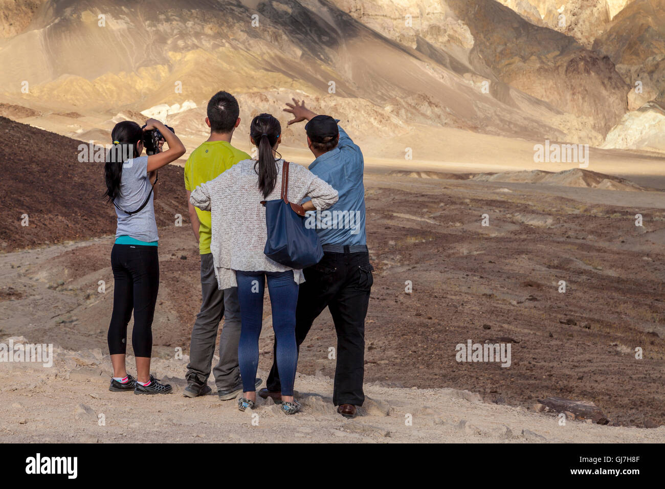 Famiglia di fotografare il vulcanico e rocce sedimentarie sulle colline vicino a artista della tavolozza in Parco nazionale della Valle della Morte, California, US Foto Stock